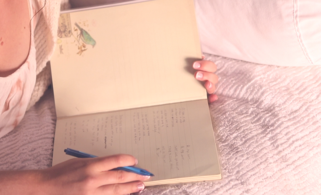 Jessica writing lyrics in notebook