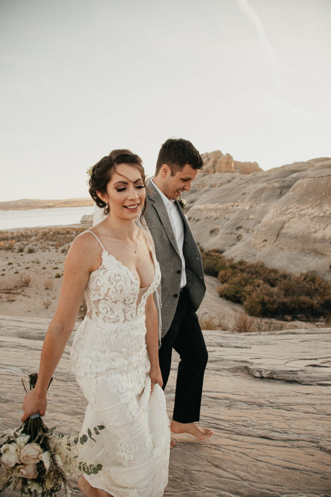 Newlyweds climb a desert canyon in Lake Powell, AZ on adventure elopement