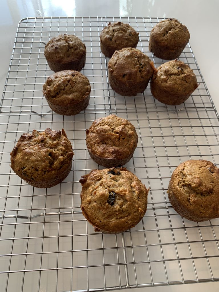 Spiced cinnamon raisin muffins on a cooling rack.