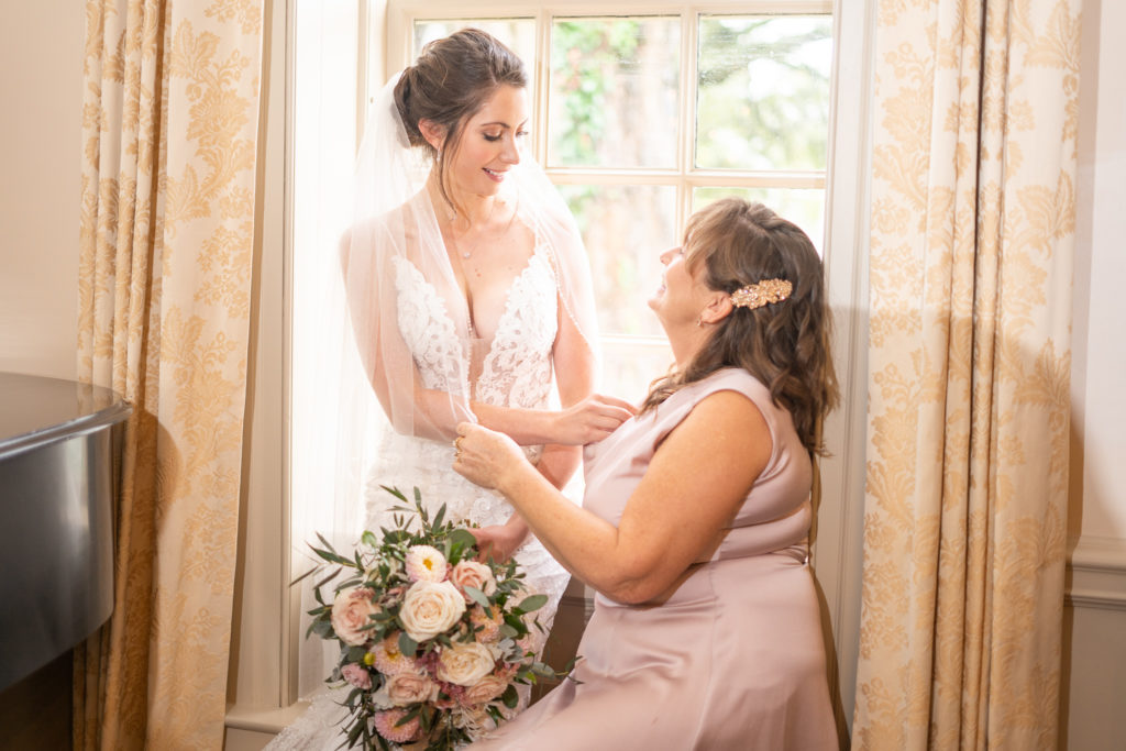 Mother and daughter in wedding dress sitting on piano at small wedding elopement at Colonial Williamsburg Inn